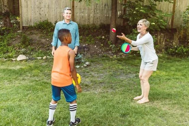 Une famille joue au ballon dans le jardin d'un centre social